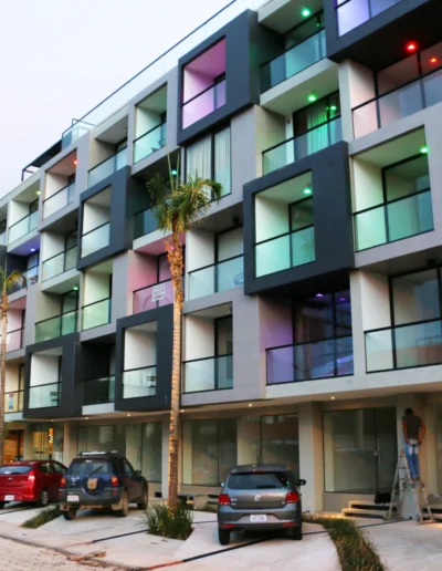 Fachada dinámica del Edificio Nano en Equipetrol con iluminación LED y oficinas en contenedores marítimos.